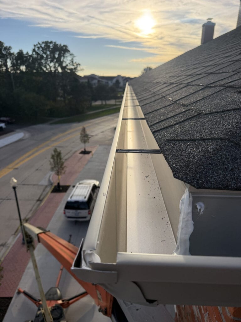 Newly installed gutter guard system on a residential roof in Macomb County, Michigan.
